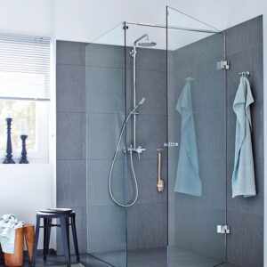 Glazen douchewand in een hoek met een vast paneel.